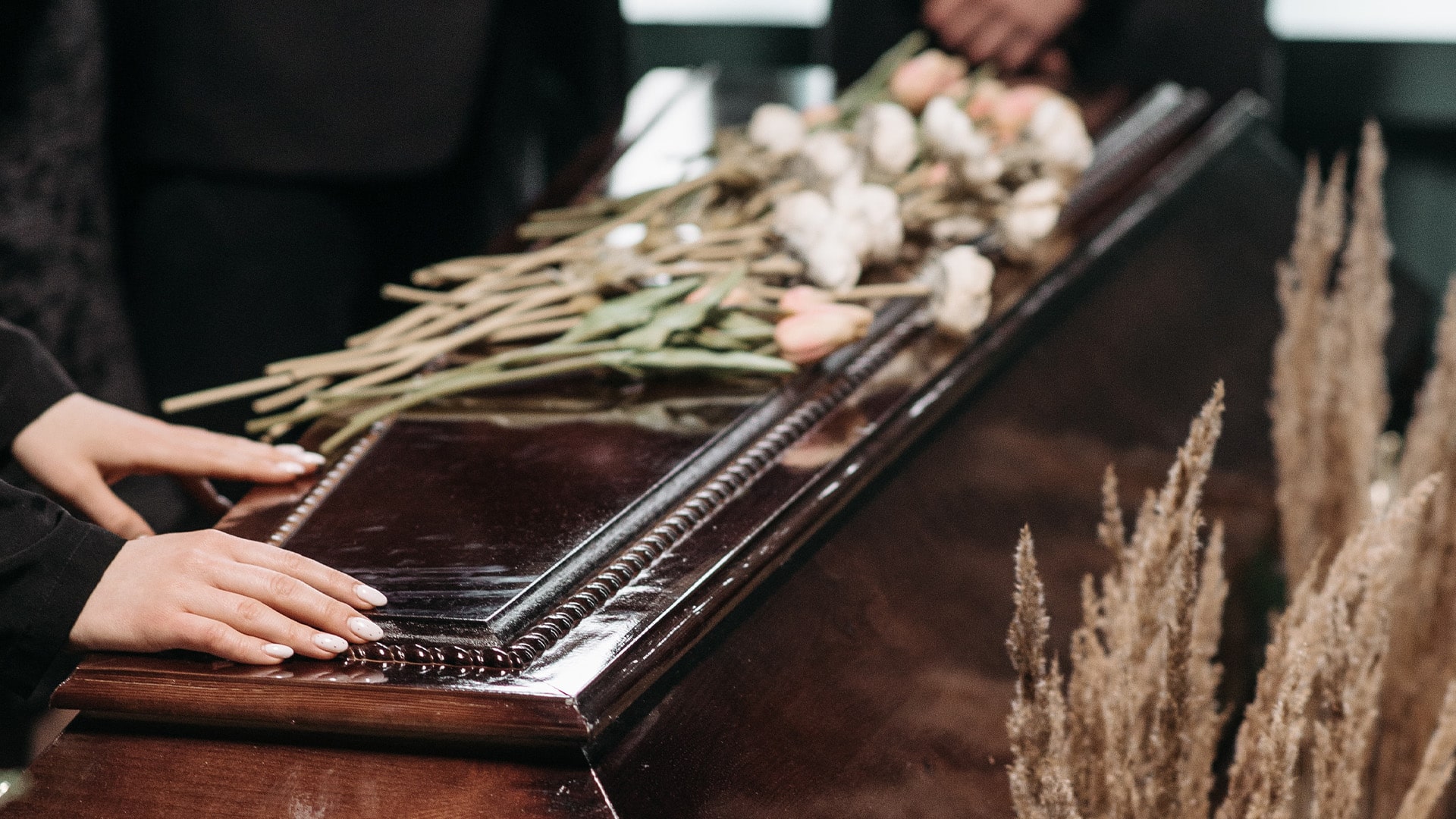 A small group of people standing around a casket